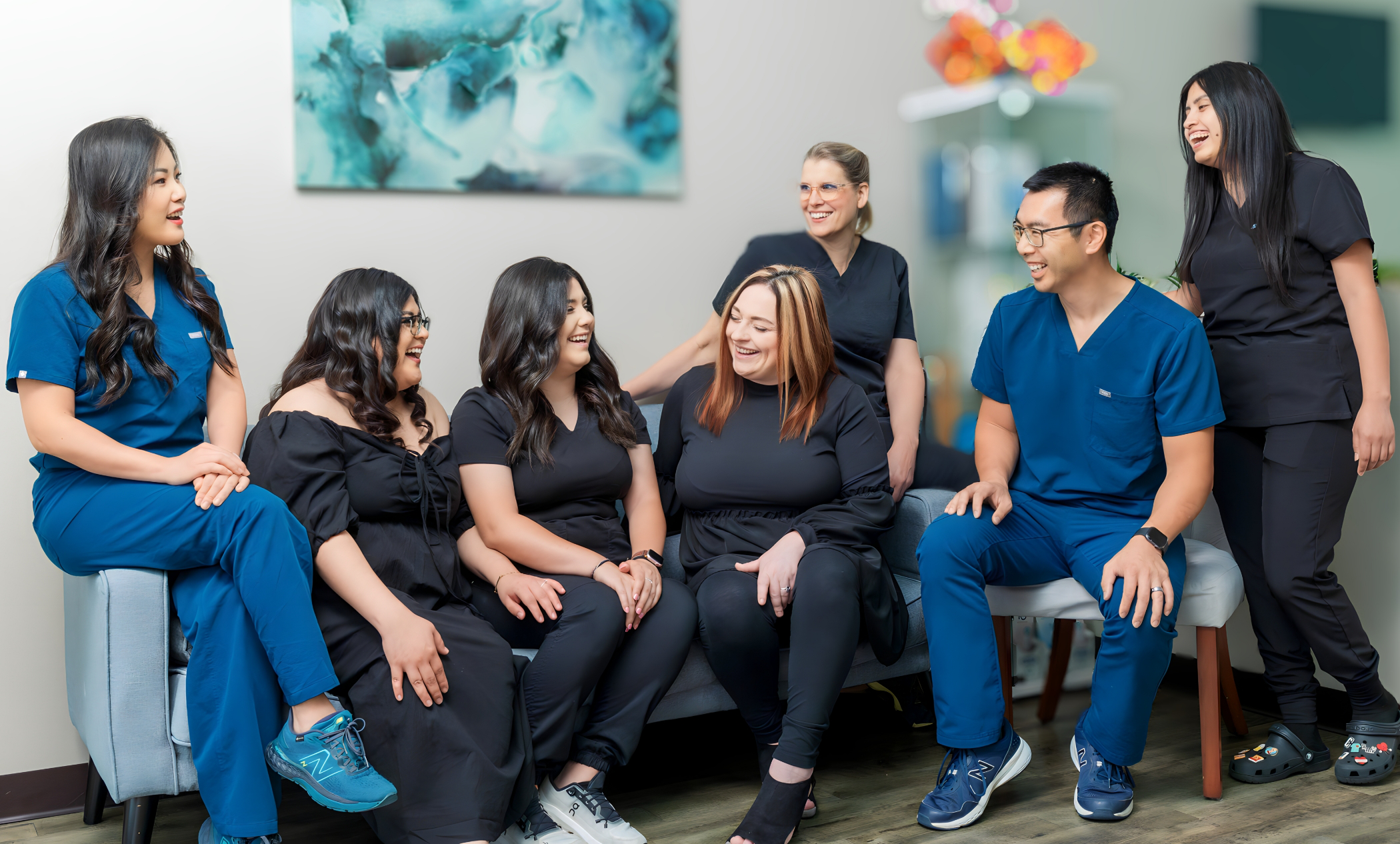 Dental team members sitting in group and smiling