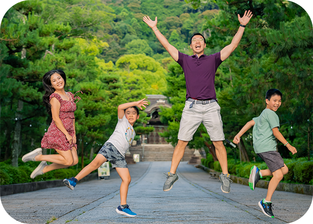 Dr Yip and her family jumping in a park