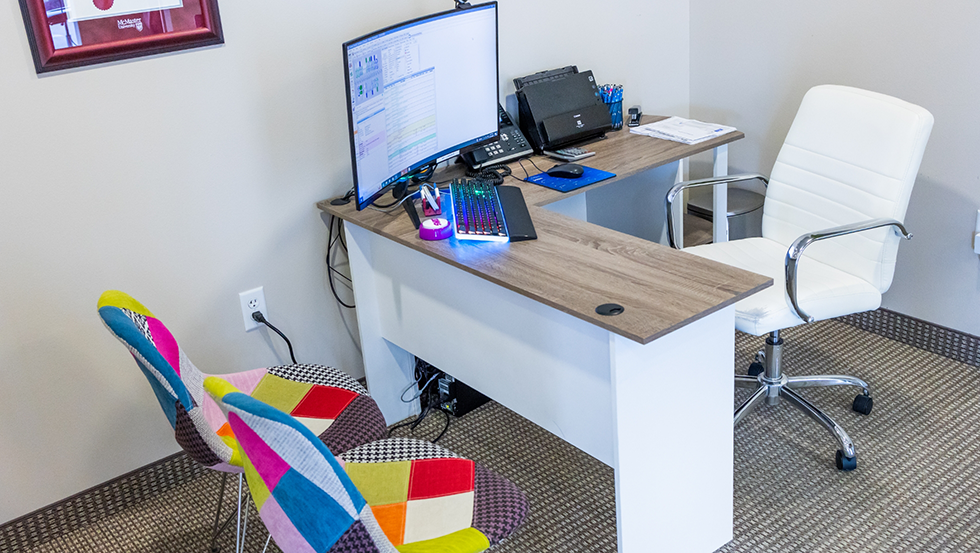 Desk in dental office with two colorful chairs for patients