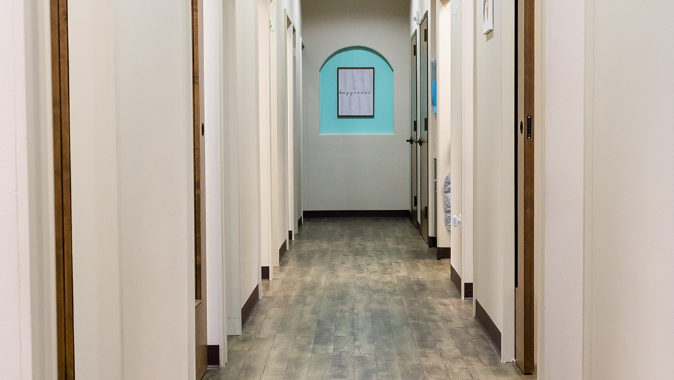 Hallway in dental office with doorways leading to treatment areas