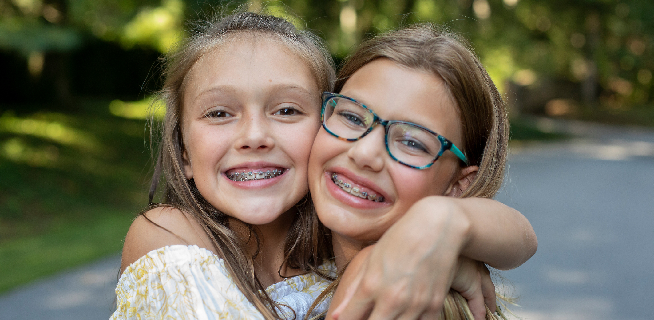 Two girls with braces hugging each other