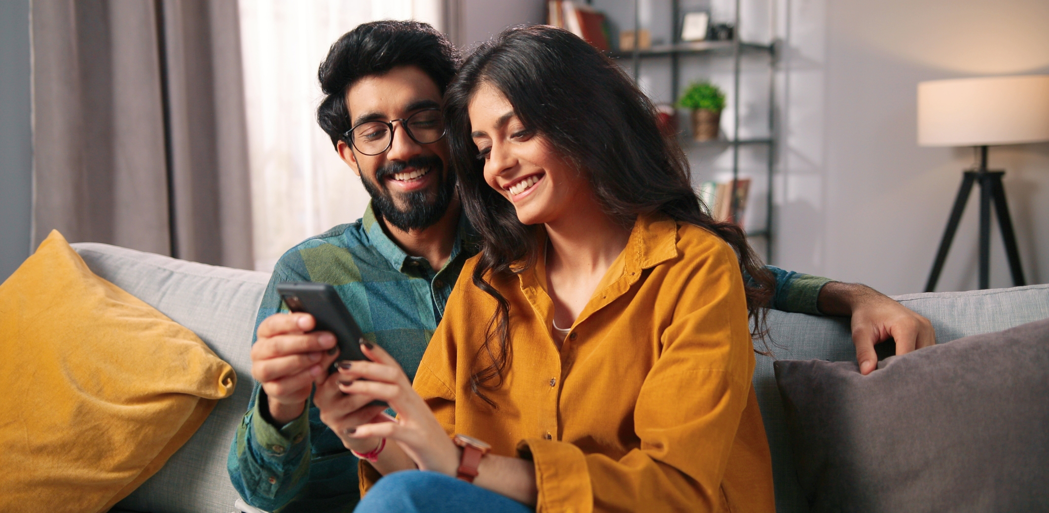 Man and woman sitting on couch smiling