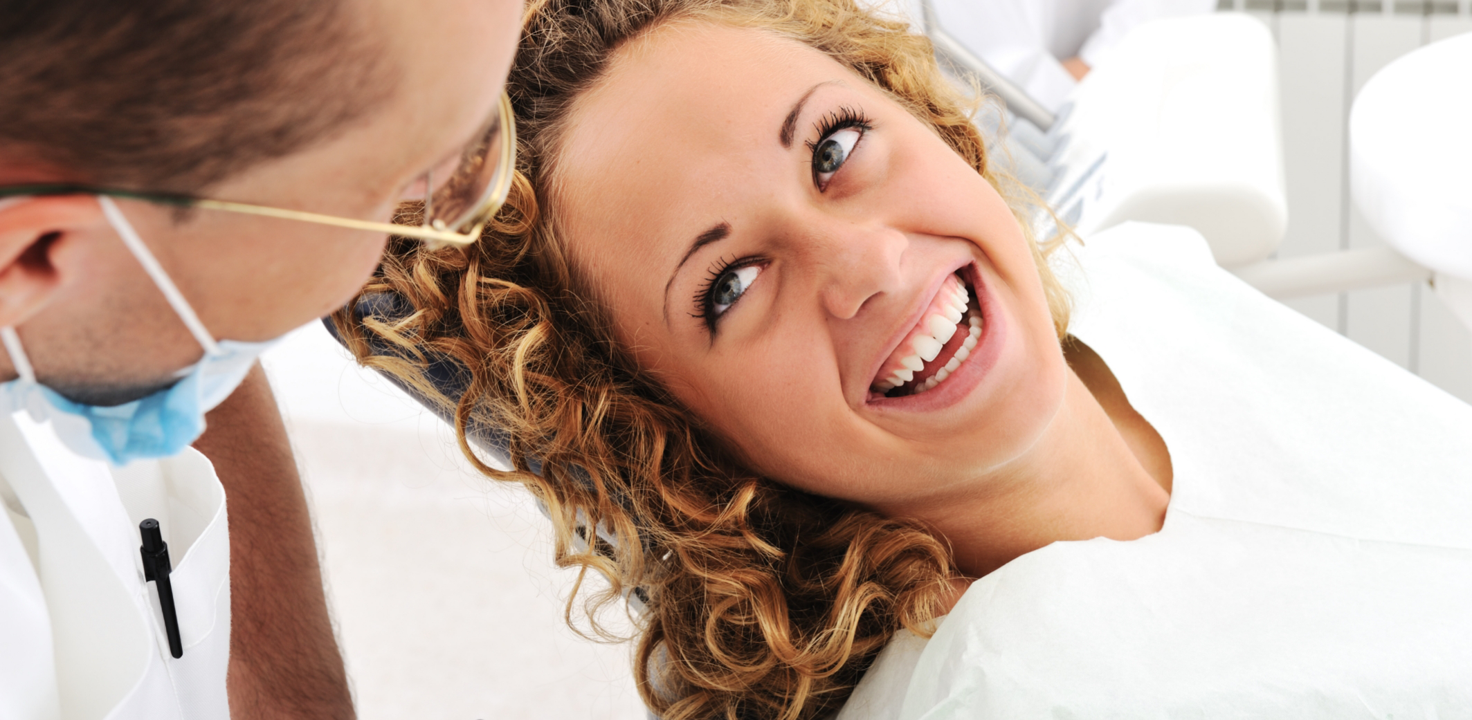 Woman smiling and looking up at dentist